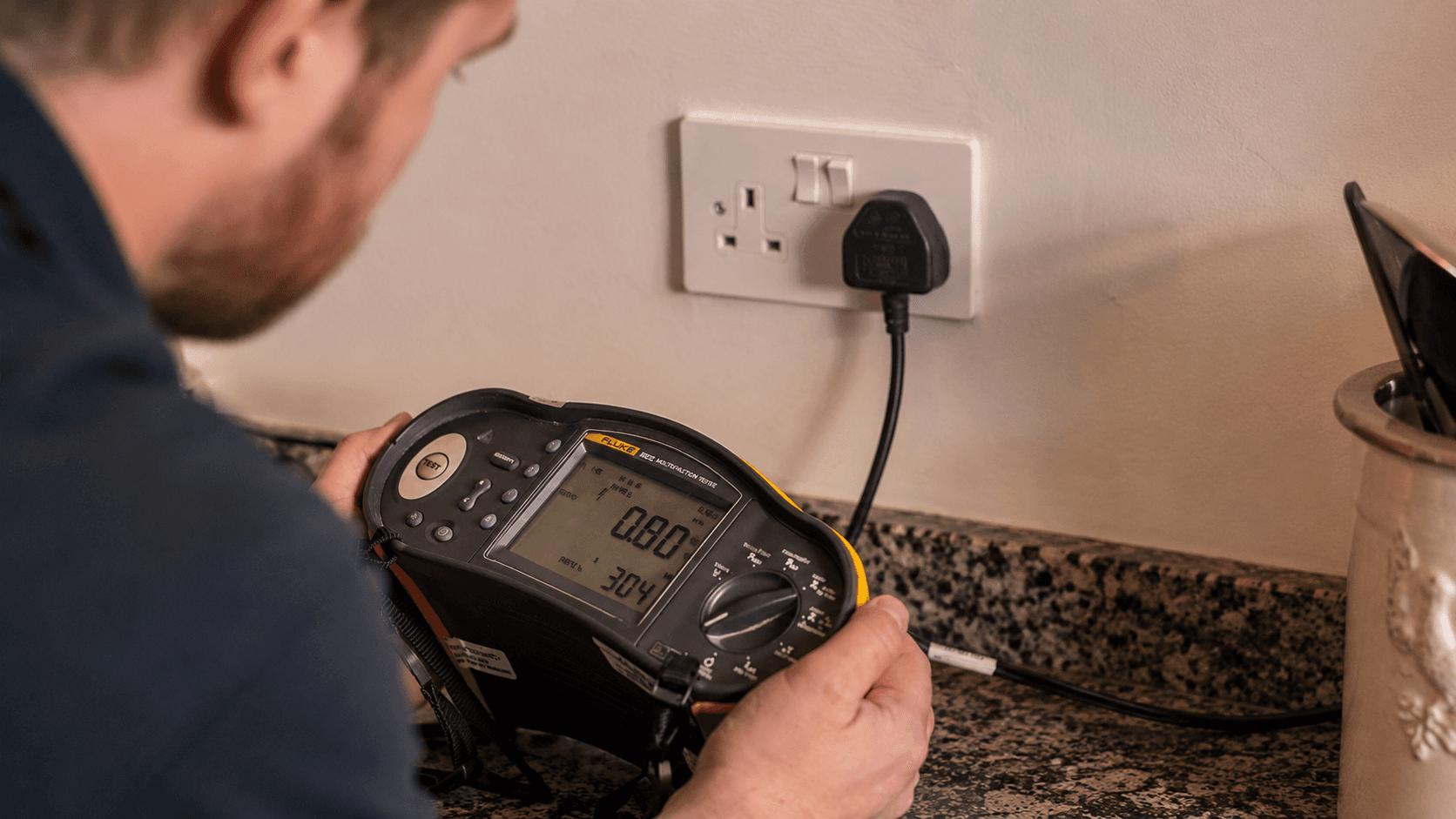 Electrician using test equipment during electrical fault finding