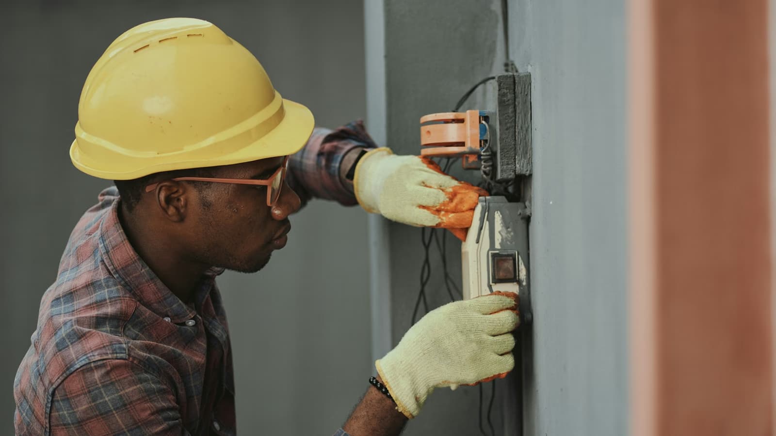 Male electrician fitting wall wiring during a house rewire